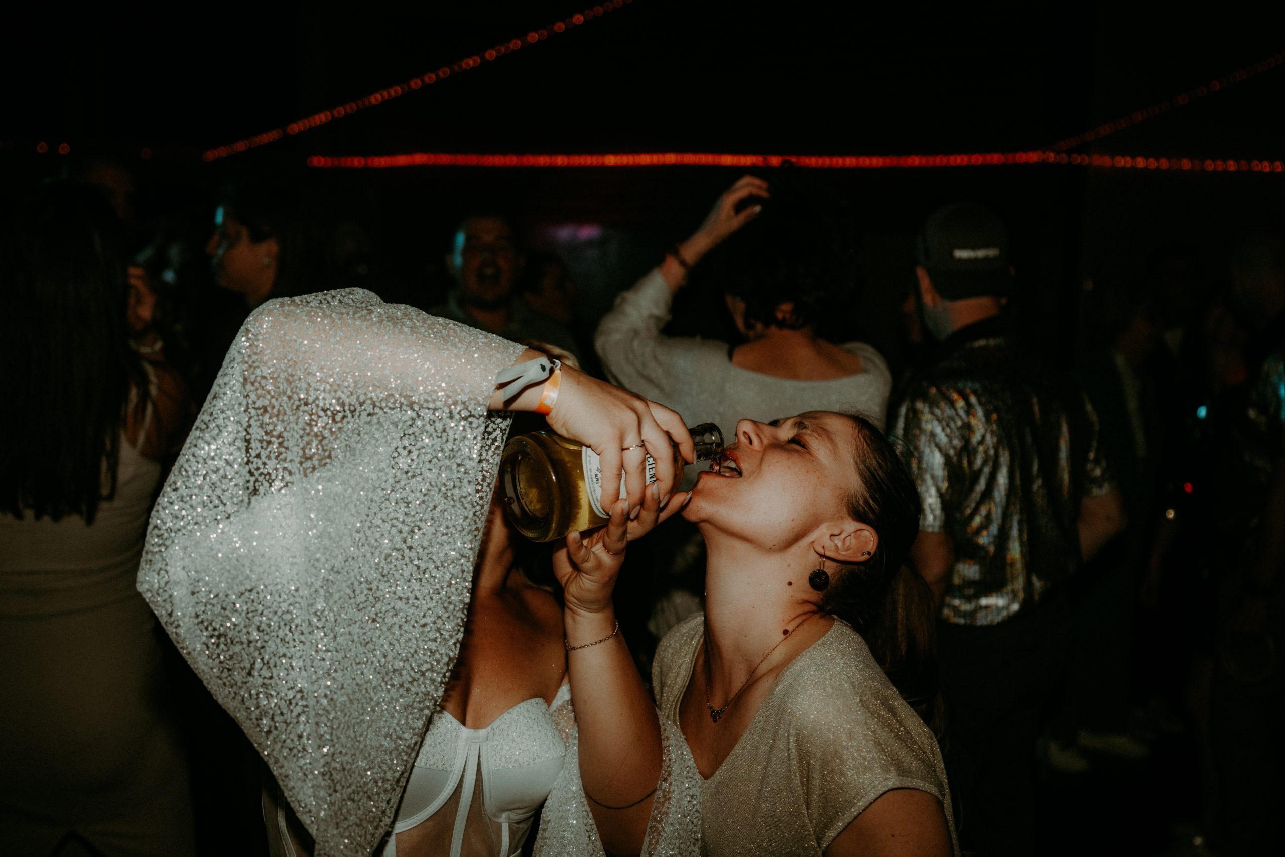 mariée qui boit un alcool fort avec une invitée pendant sa soirée de mariage sur le dancefloor