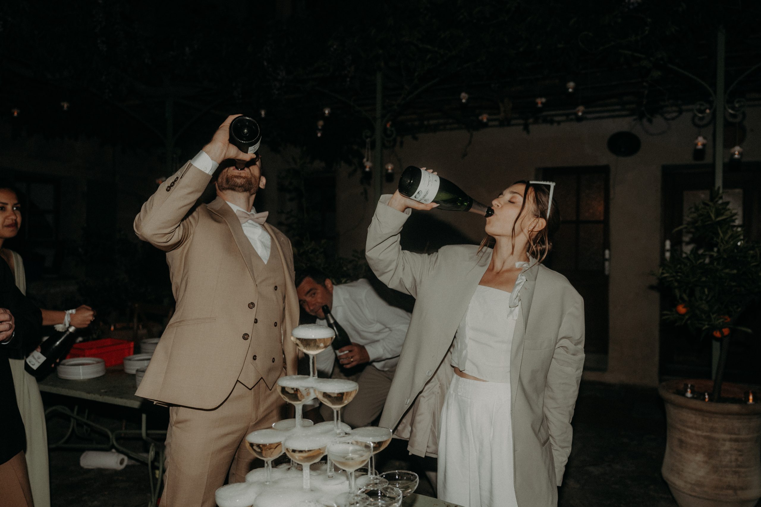 couple buvant à la bouteille au moment de servir le champagne à leur mariage au mas blanc à uzès