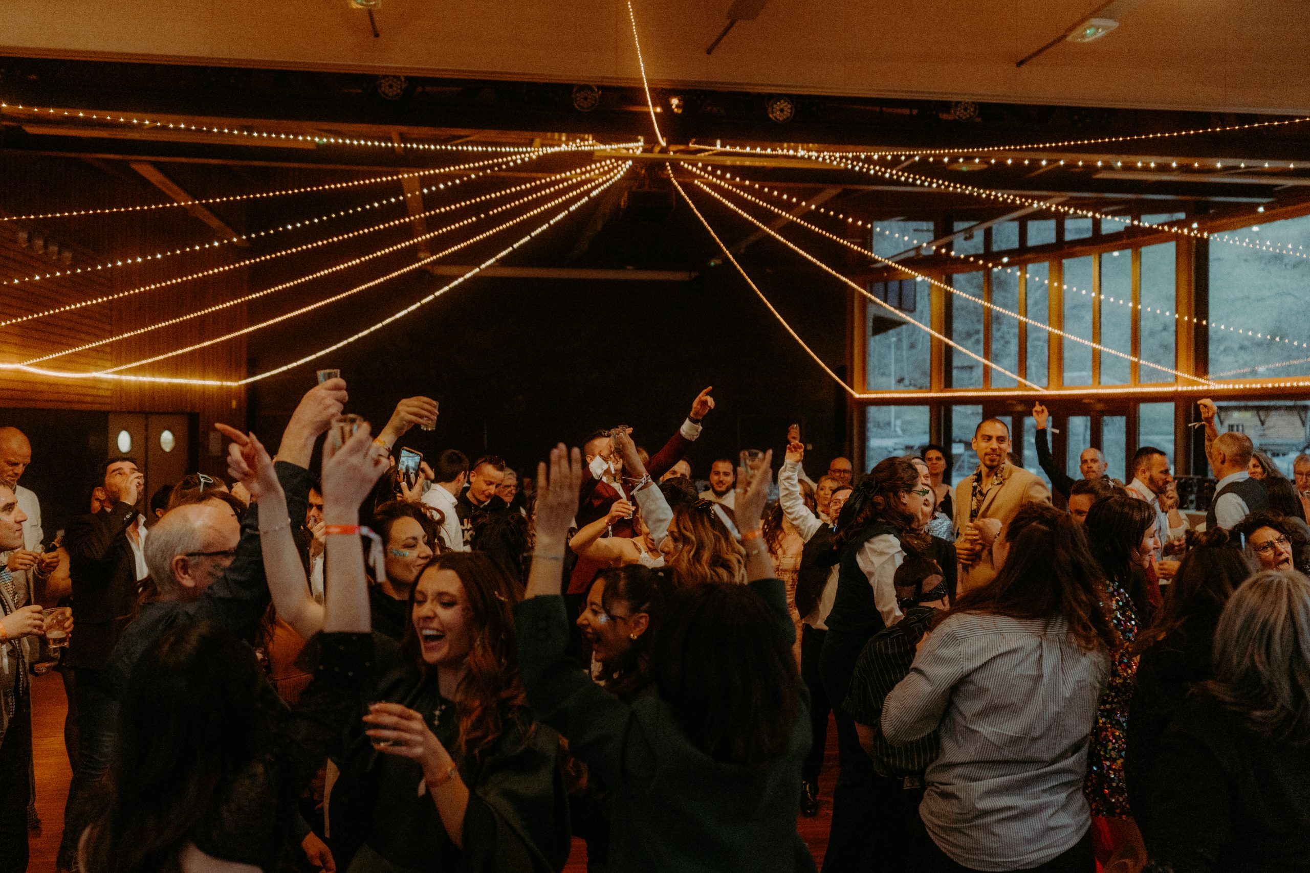 foule d'invités qui danse dans la salle de réception du domaine du baron à montriond