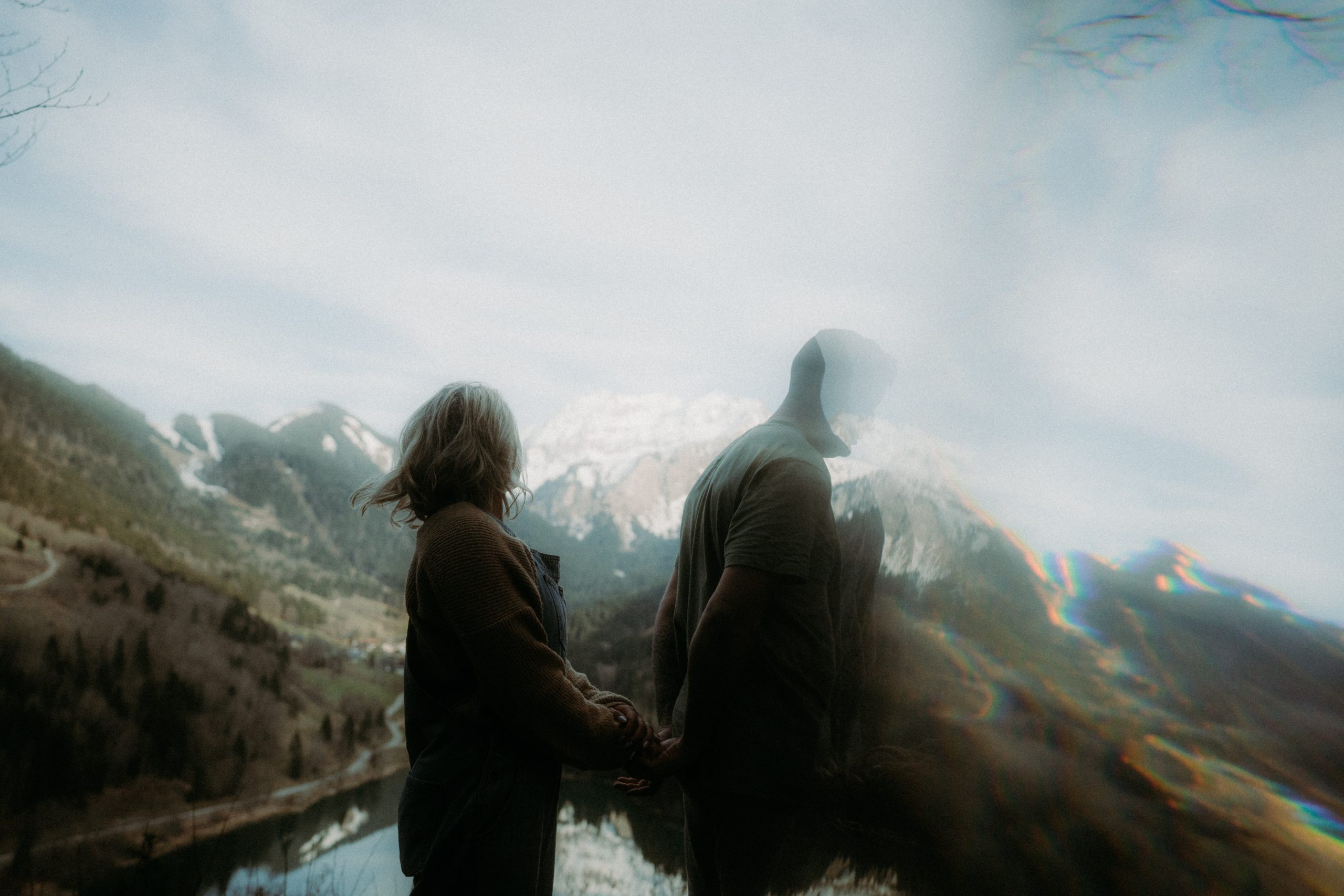 séance photo engagement d'un couple se tenant la main en regardant les montagnes au lac de vallon