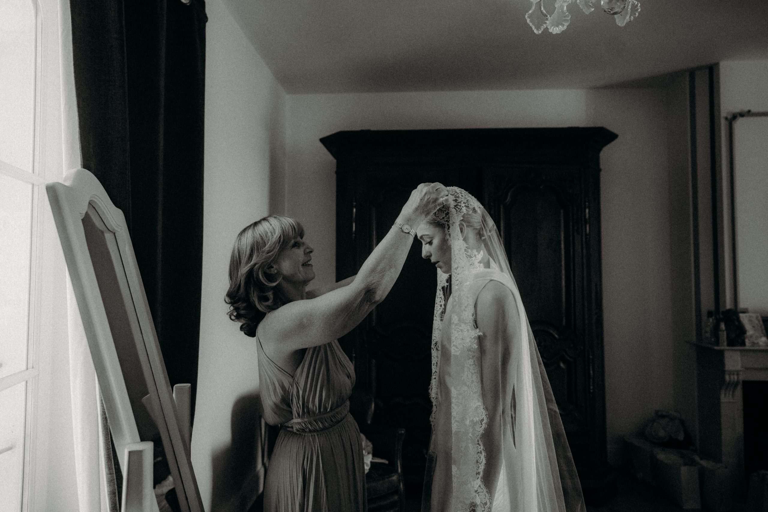 mariée habillée de son voile par sa maman au domaine de la fauconnie en dordogne