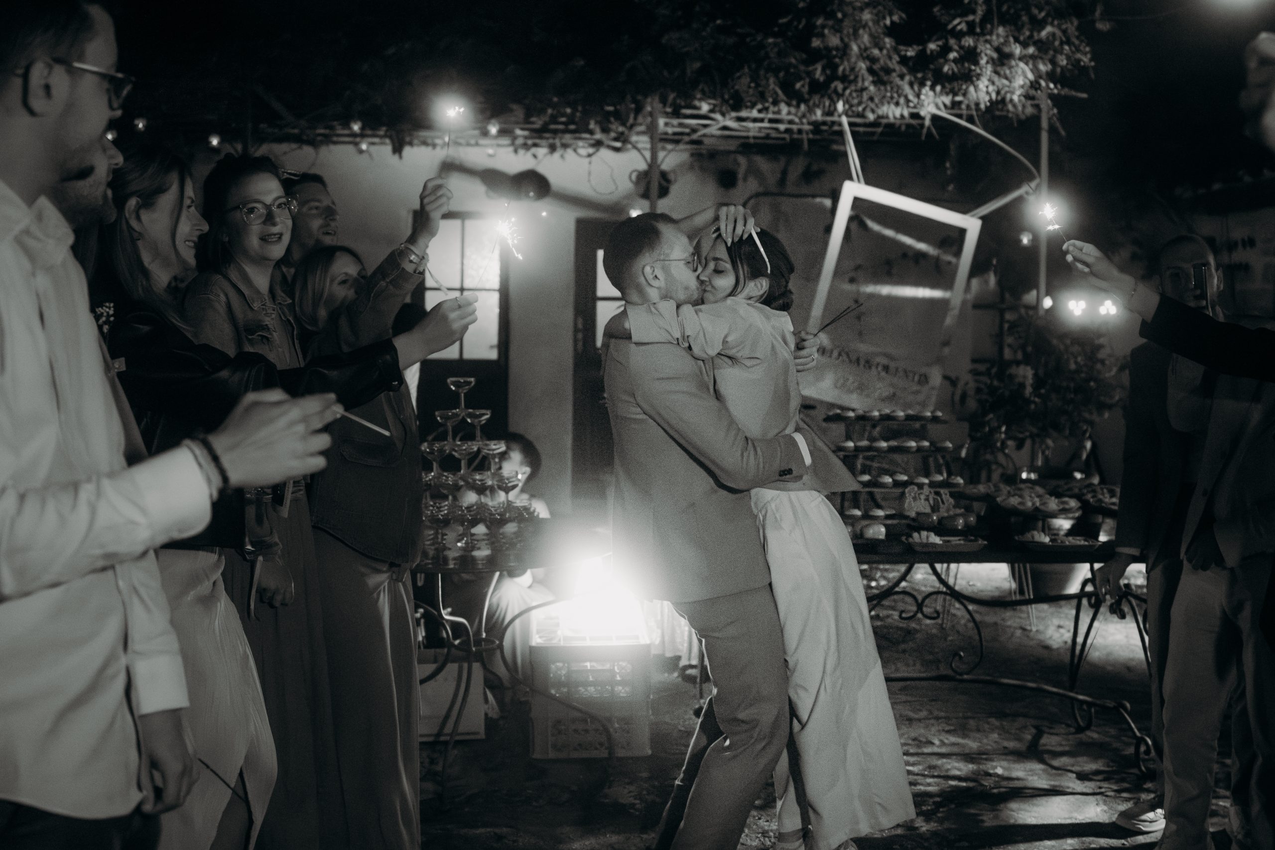 mariés qui s'enlacent entourés de cierges magiques la nuit