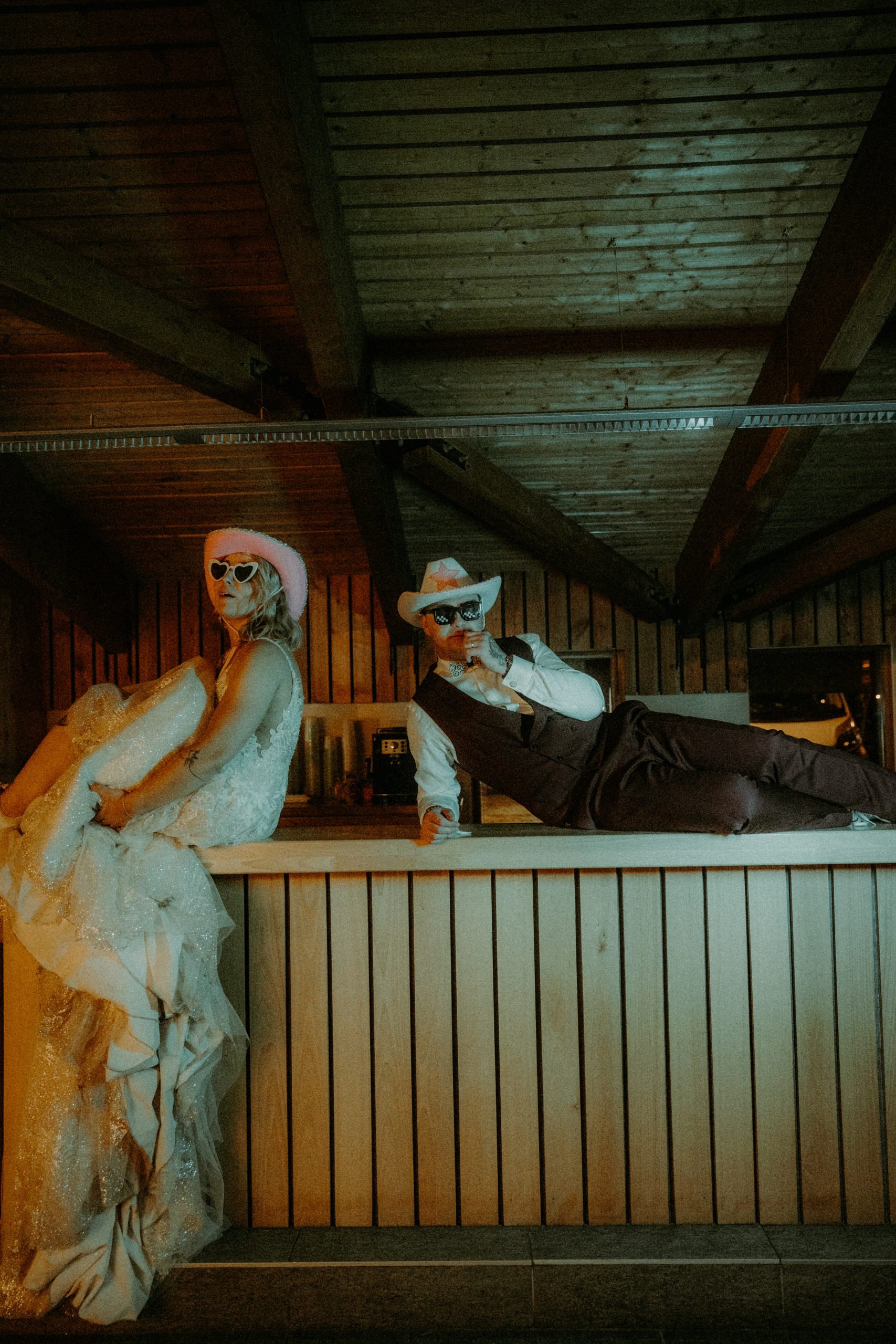 couple de mariés rock'n'roll assis sur le bar au domaine du baron